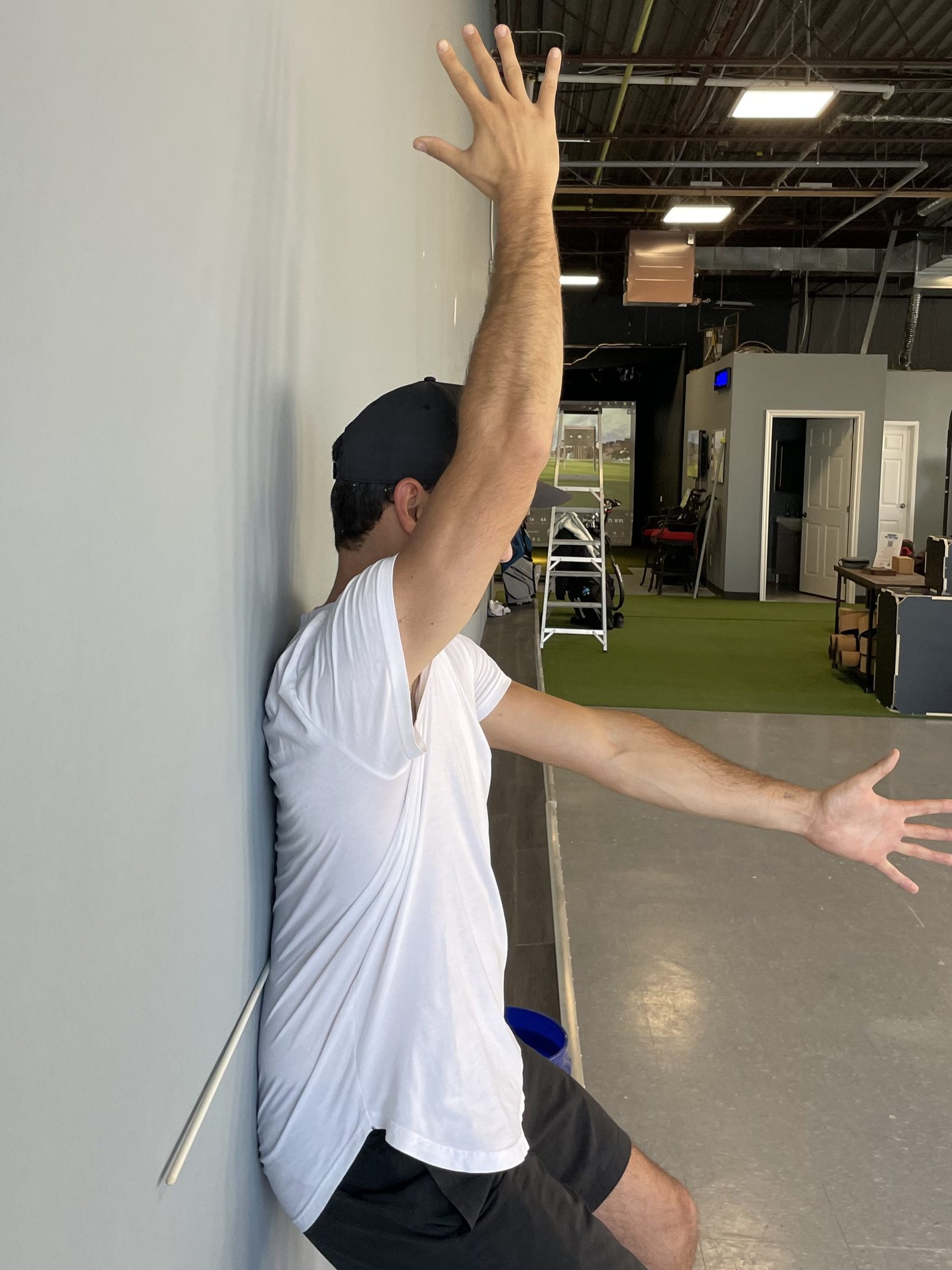 Student performing banded squat drill with full training facility visible