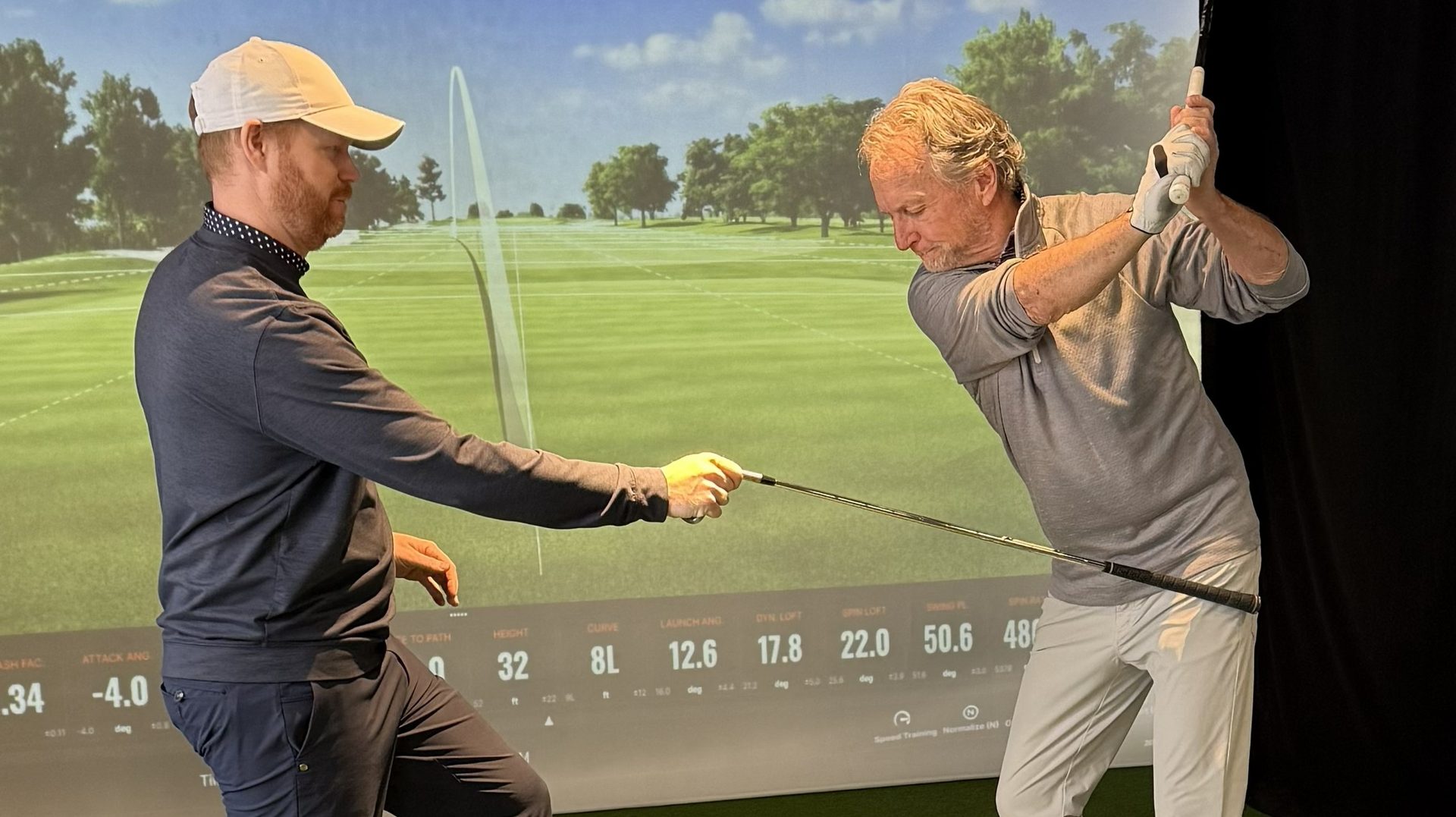 Student at top of backswing with Swing Catalyst pressure heatmap and TrackMan sim data